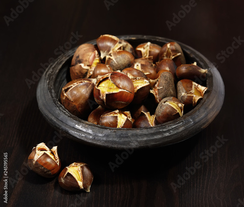 roasted chestnuts in a bowl on a wooden background