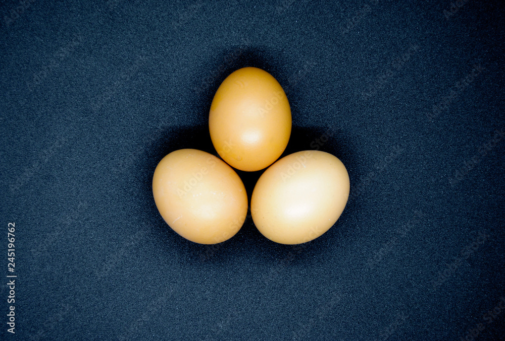 Three brown eggs on the black background Three brown eggs on the black background