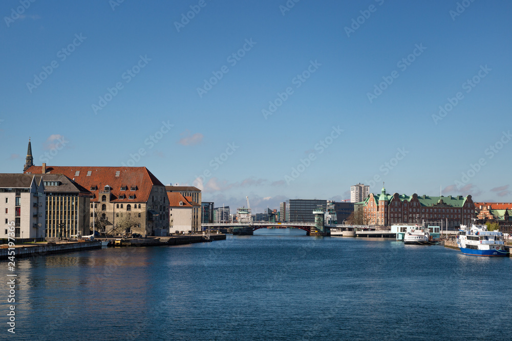 COPENHAGEN, DENMARK. Waterfront of Christianshavn district on the left side and Tietgens Hus and Borsen buildings and boats on the right
