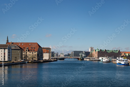 COPENHAGEN, DENMARK. Waterfront of Christianshavn district on the left side and Tietgens Hus and Borsen buildings and boats on the right