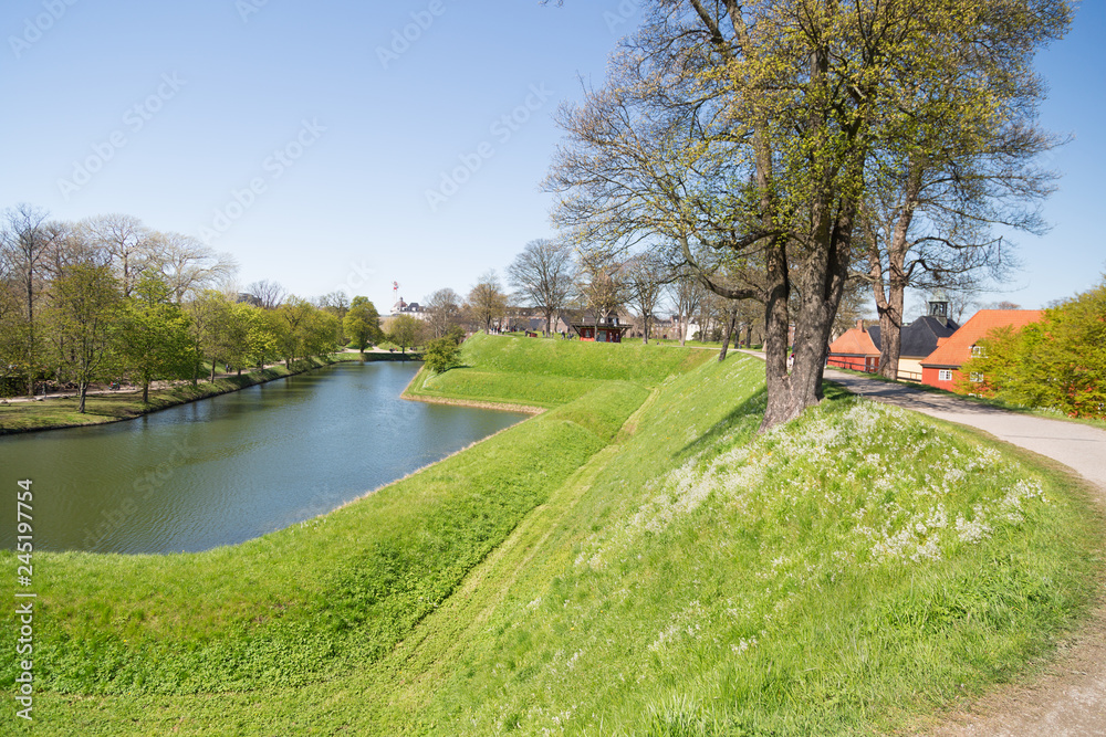 Canal and the prison complex on the rear side of the church in citadel Kastellet, one of the best preserved star fortresses in Northern Europe. Copenhagen, Denmark. Spring. Canal and the prison complex on the rear side of the church in citadel Kastellet, one of the best preserved star fortresses in Northern Europe. Copenhagen, Denmark. Spring.