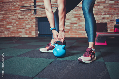 Sporty Woman holding kettlebell in gym. Workout concept
