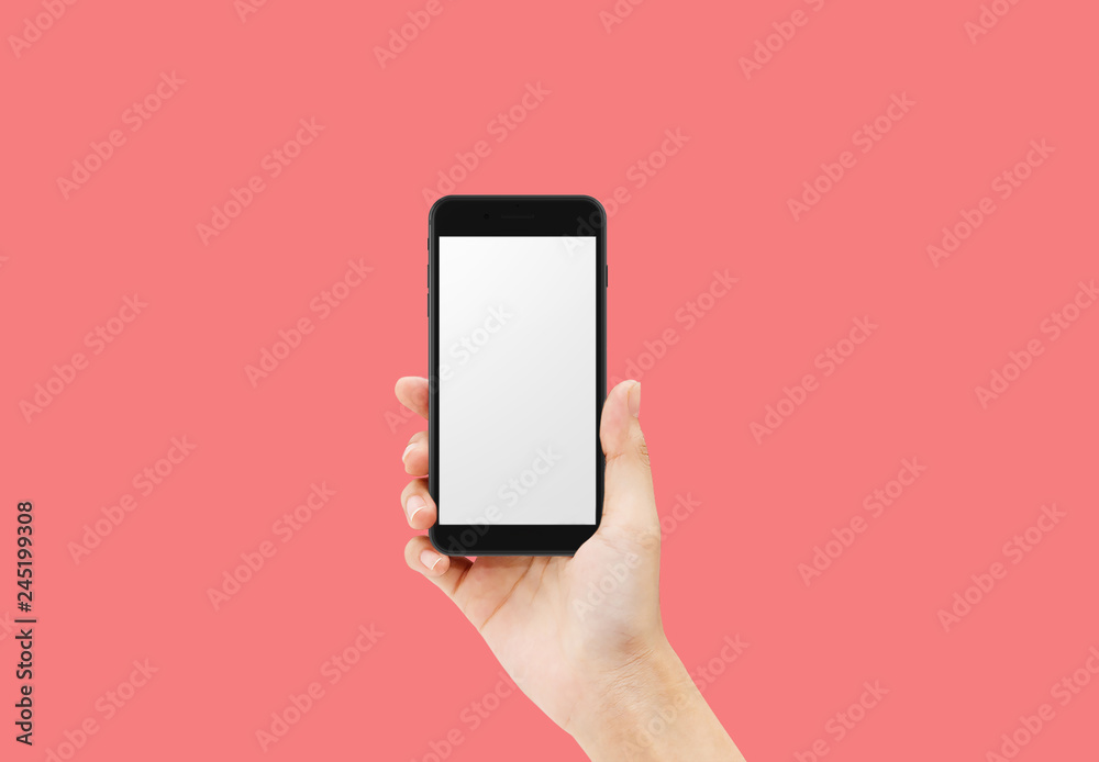 Hand holding black smartphone isolated on red background
