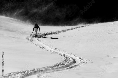 Rear view of skier skiing on snowy landscape photo