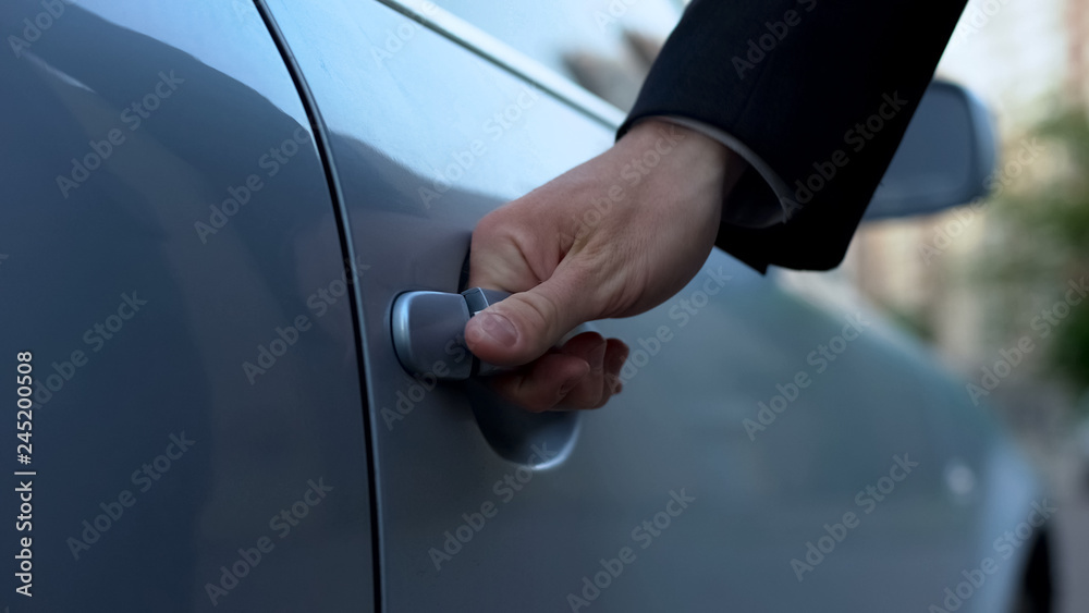 Businessman opening car door near residential complex in morning, going to work