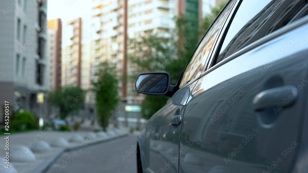 New car parked near real estate complex in morning, property insurance services