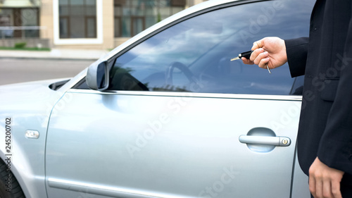 Businessman turning off car alarm, getting into auto, safety system, insurance © motortion