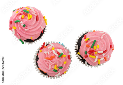 Three pink frosted chocolate cupcakes isolated on a white background top view.
