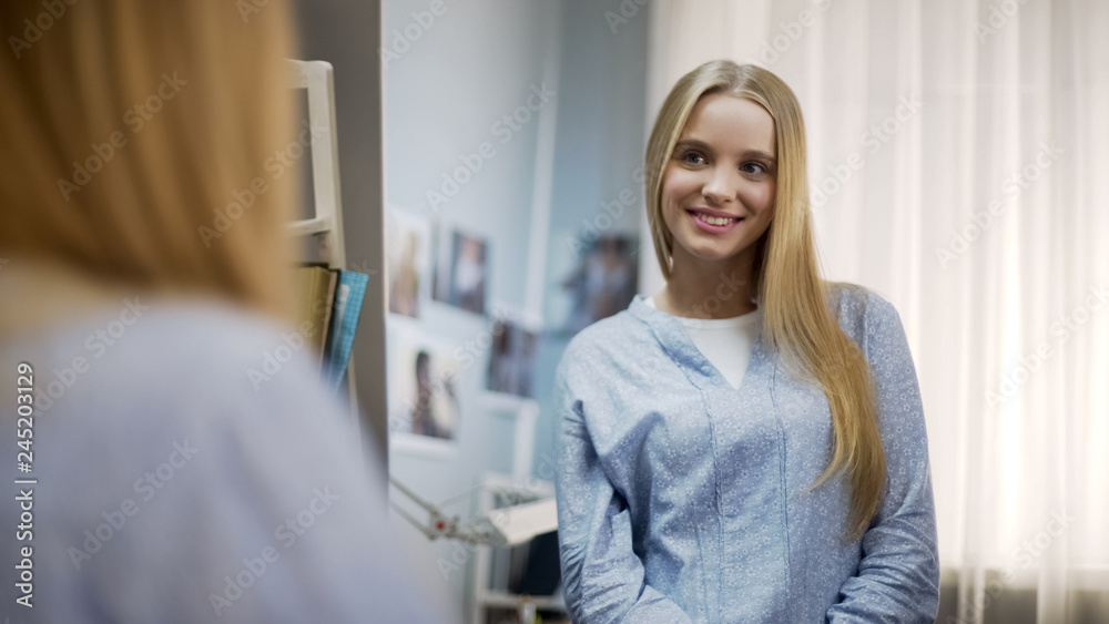 Happy teenage girl looking at mirror, enjoying life, healthy skin and hair Happy teenage girl looking at mirror, enjoying life, healthy skin and hair