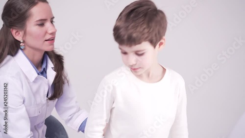doctor is palpating abdomen of a small patient. 7 years old boy, medical checkup