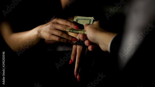Businessman in car giving money to prostitute, illegal sex trade, female escort
