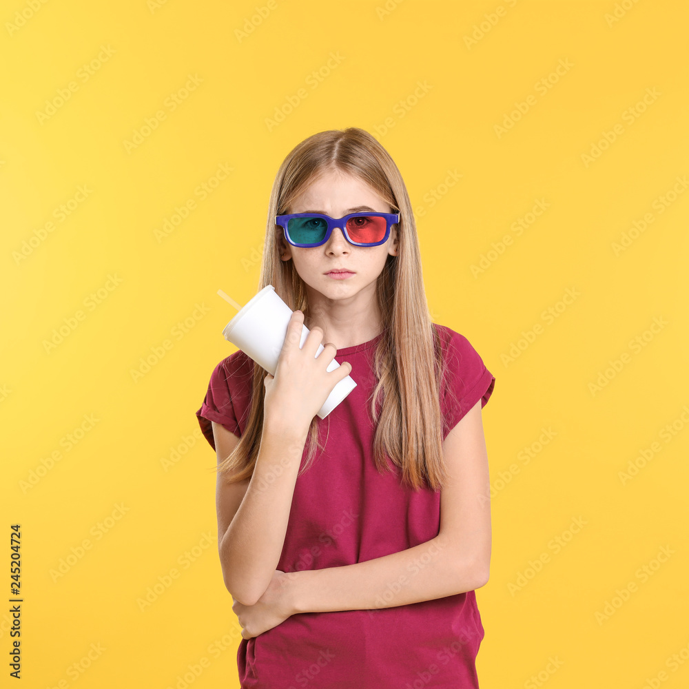 Emotional teenage girl with 3D glasses and beverage during cinema show on color background Emotional teenage girl with 3D glasses and beverage during cinema show on color background