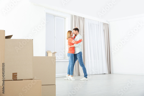 Happy couple dancing near moving boxes in their new house