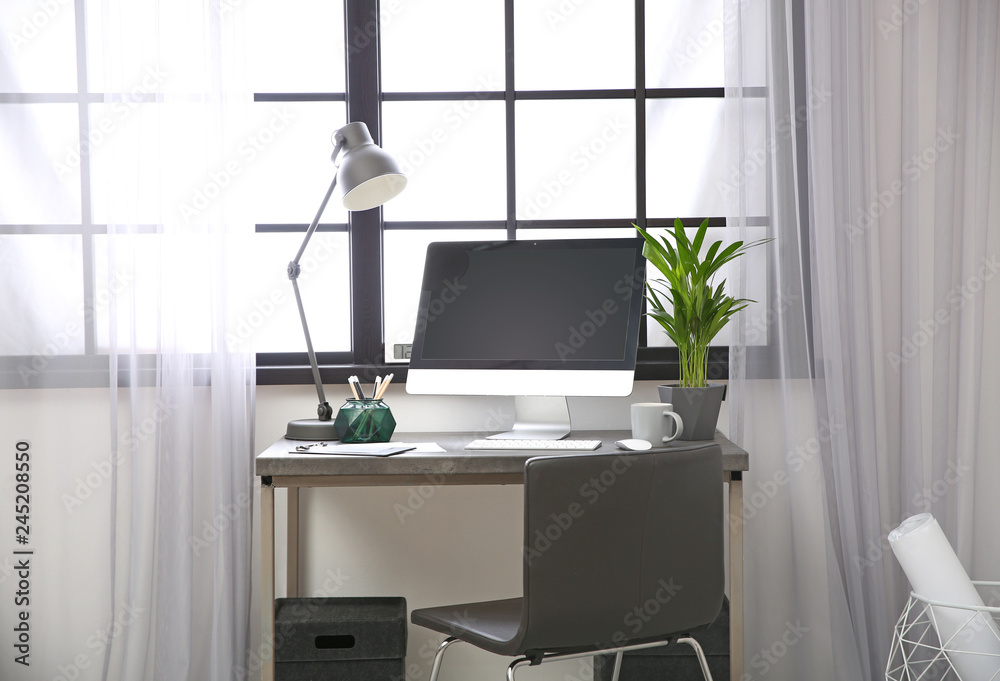 Stylish workplace with computer near window at home office. Space for text Stylish workplace with computer near window at home office. Space for text