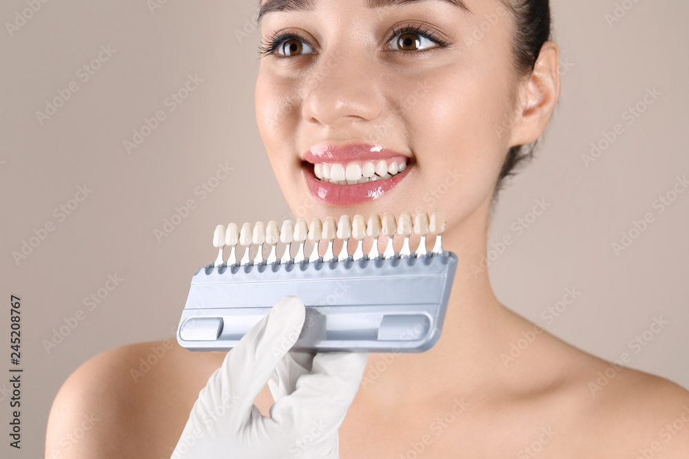 Dentist checking young woman's teeth color, closeup Dentist checking young woman's teeth color, closeup