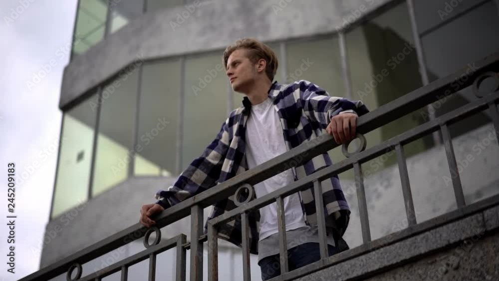 Young man walking along bridge Young man walking along bridge