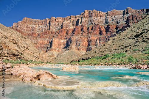 Aquamarine waters of the Little Colorado River flow towards its confluence with the Colorado River in Marble Canyon