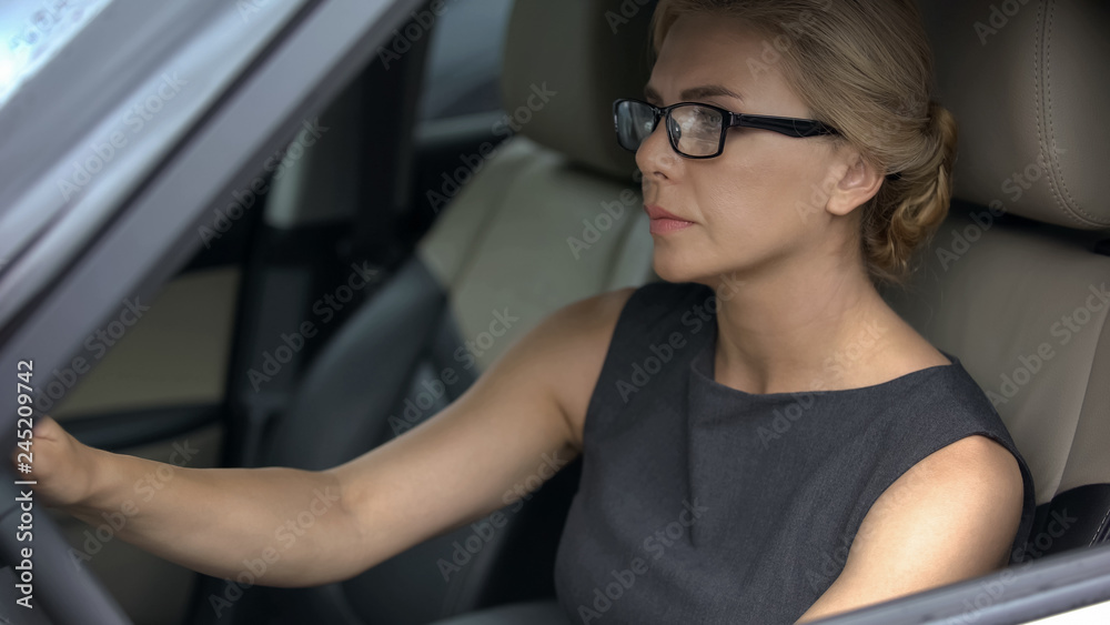 Serious business lady in car, driving to important meeting with partners, work