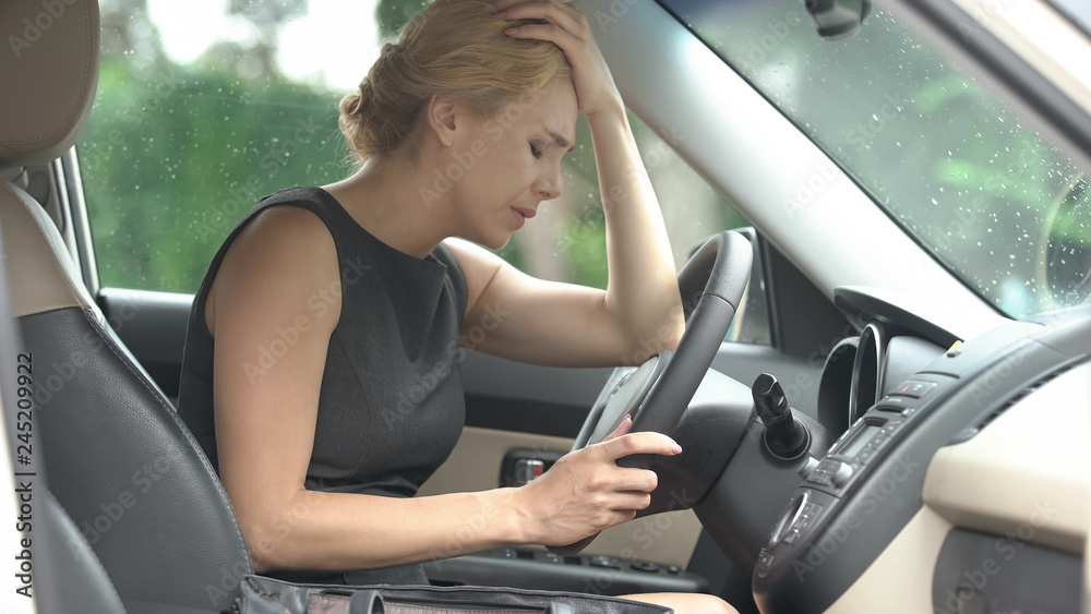 Exhausted female in automobile suffering from strong headache, stressful life