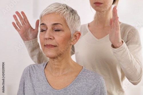 Woman having reiki healing treatment , alternative medicine concept, holistic care photo