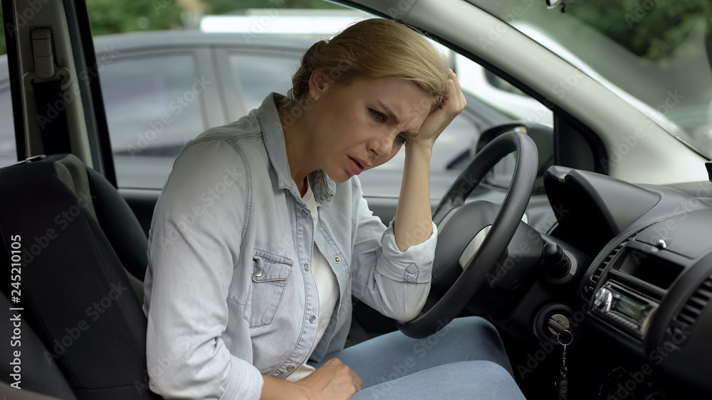 Depressed casual woman sitting in car, dissatisfied with her life, daily routine
