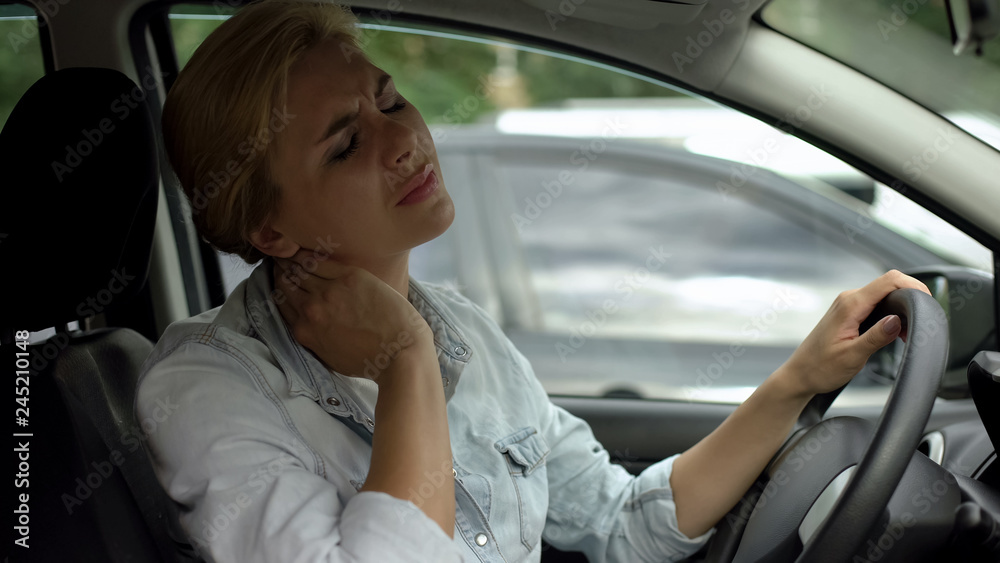 Lady sitting in car feeling neck pain, sedentary life, lack of physical activity