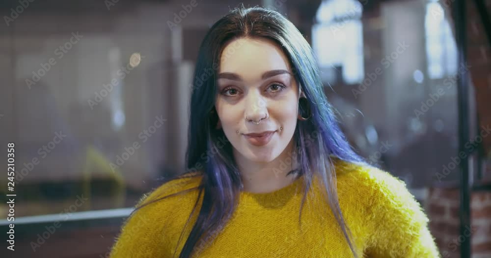 Confident blue hair woman with piercings smiling portrait.Freelancer,small business owner or student at studio office, coworking or school.People wearing casual.Modern,growth,success.4k video Confident blue hair woman with piercings smiling portrait.Freelancer,small business owner or student at studio office, coworking or school.People wearing casual.Modern,growth,success.4k video