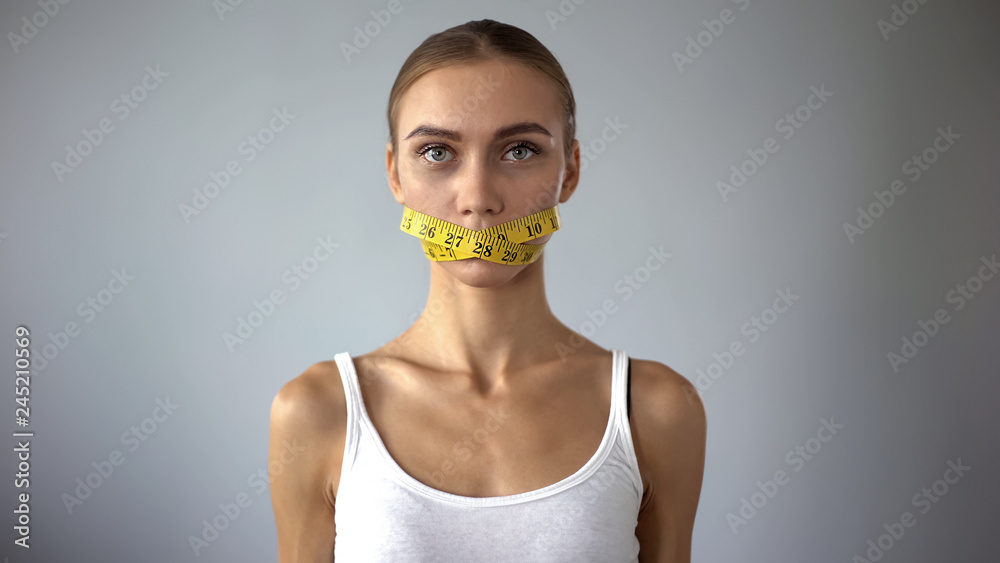 Lady with tape closing mouth looking at camera, weight loss calculating calories - obrazy, fototapety, plakaty 