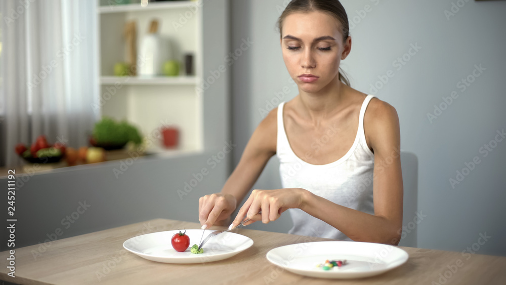 Girl eats spinach, looks at anti-obesity pills, drugs as easy way to lose weight Girl eats spinach, looks at anti-obesity pills, drugs as easy way to lose weight
