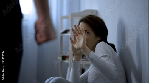 Woman trying to protect herself from fists of enraged husband, assault in family