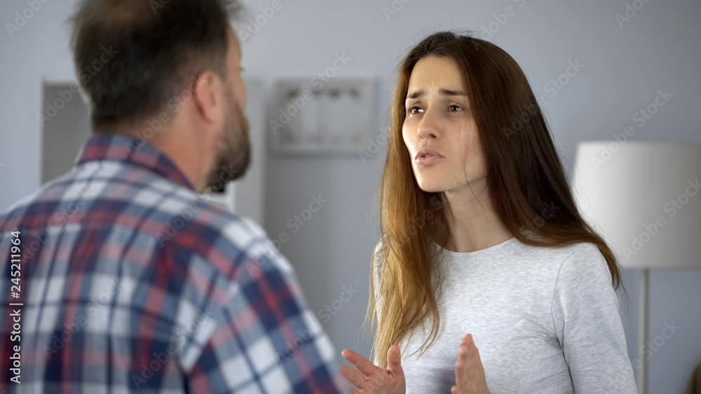 Pale woman arguing with aggressive husband, suffering from domestic violence Pale woman arguing with aggressive husband, suffering from domestic violence