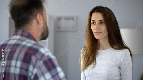 Exhausted lady suffering from domestic violence, arguing with aggressive husband
