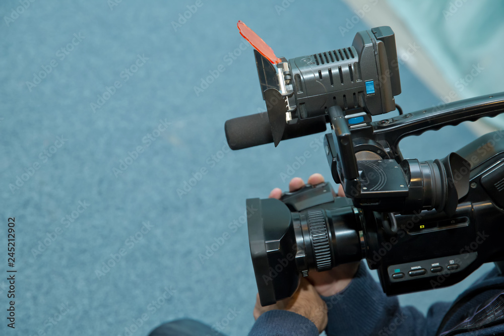 Covering an event with a video camera., Videographer takes video camera with free copy space for text., Video camera operator working with his equipment., close up of television operator with camera.