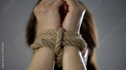Woman hands tied up with rope, human trafficking, kidnapped woman, hostage