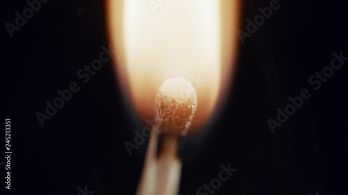 An unlit match bursts into flame in extreme closeup. It’s extinguished and the smoke swirls until it’s gone. Filmed in slow motion. 