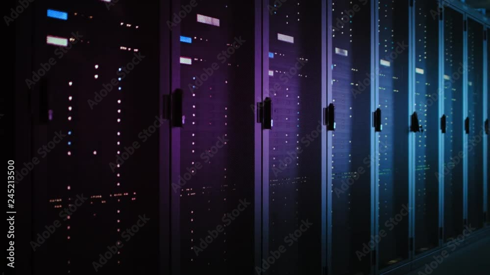 Moving Data Shot of Dark Data Center With Multiple Rows of Fully Operational Server Racks. Modern Telecommunications, Cloud Computing, Artificial Intelligence, Database, Supercomputer. Neon Light Moving Data Shot of Dark Data Center With Multiple Rows of Fully Operational Server Racks. Modern Telecommunications, Cloud Computing, Artificial Intelligence, Database, Supercomputer. Neon Light