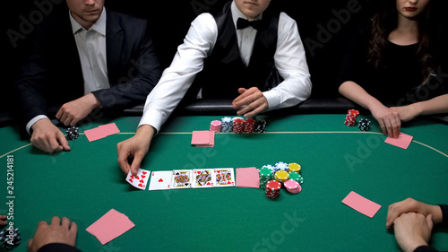 Poker dealer turning up cards at green casino table, hobby tournament, luck