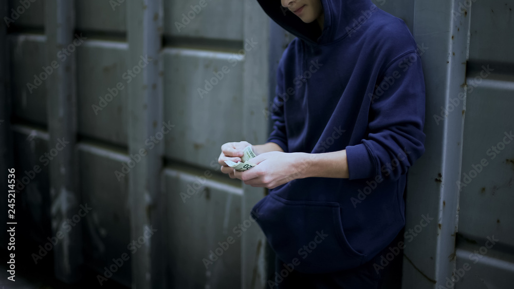 Αυτοκόλλητο Poor boy secretly counting cash from pocket, poverty in beggar area, depression