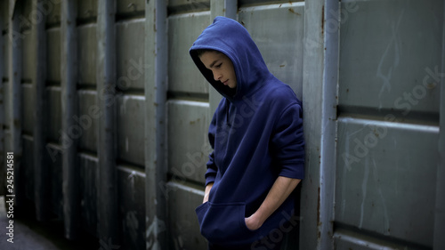 Foto Homeless boy wandering in cold dark backstreet, lost in life, awkward age