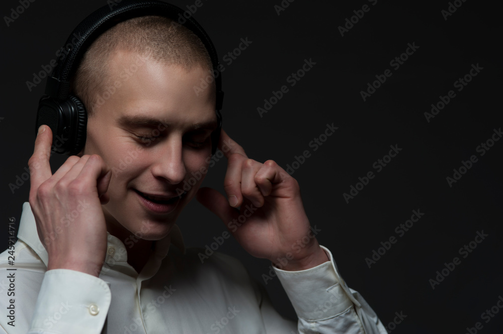 Positive young guy DJ in headphones Positive young guy DJ in headphones