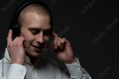 Positive young guy DJ in headphones