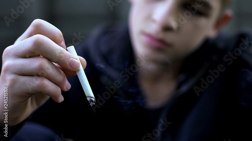 Teenager smoking cigarette, bad habits, pretending to be adult, unhealthy life