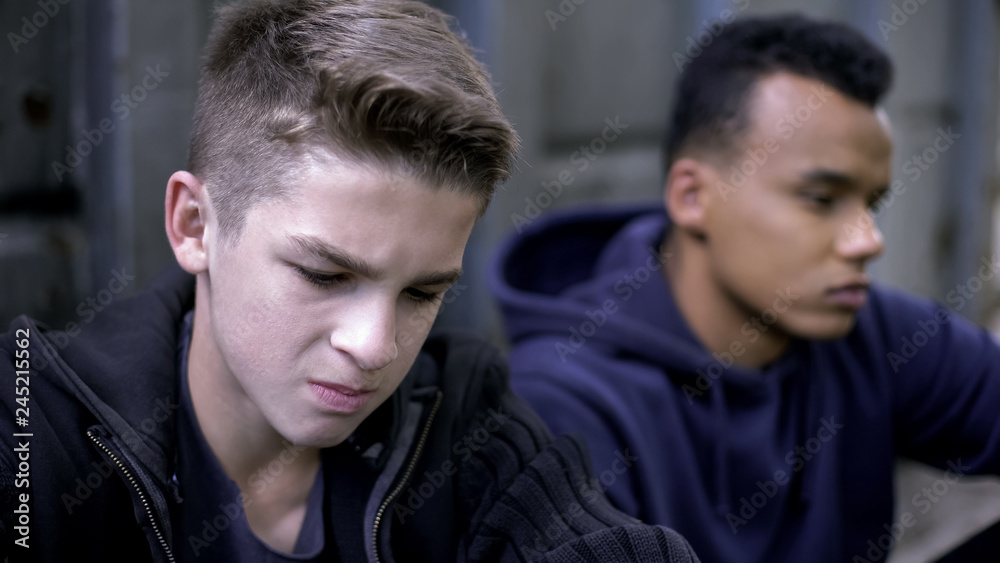 Obraz premium Two sad friends sitting in hideaway, became orphans, children of war, crying