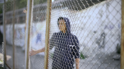 Photography Afro-american boy behind fence, migrant child separated from family, detained