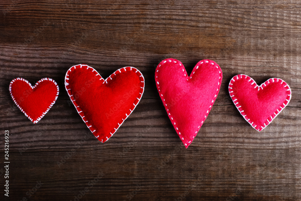 Red felt hearts on a wooden table. Handmade blank for cards, copy space. Red felt hearts on a wooden table. Handmade blank for cards, copy space.