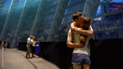 Couple embracing near shopping center, romantic date on summer evening, love