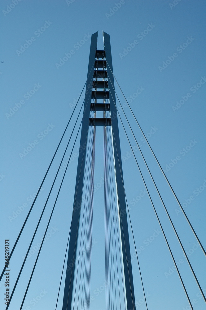 Cables and tower of the suspension bridge with blue skies in the background Cables and tower of the suspension bridge with blue skies in the background
