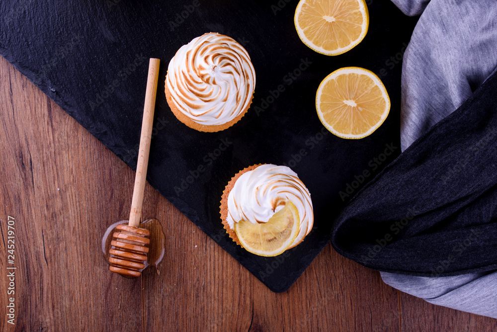 Lemon muffins with protein cream on a slate board with powdered sugar and honey Lemon muffins with protein cream on a slate board with powdered sugar and honey