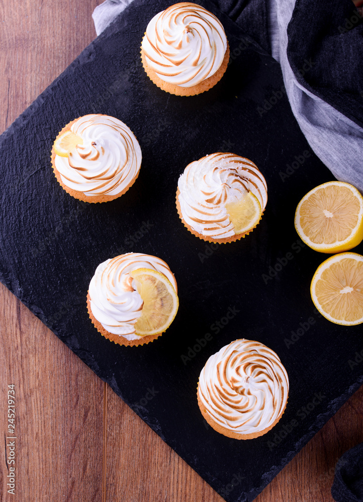 Lemon muffins with protein cream on a slate board with powdered sugar and honey
