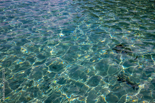 Shiny blue tropical sea water texture. Seawater closeup photo. Still sea surface. Transparent water of tropical seaside.